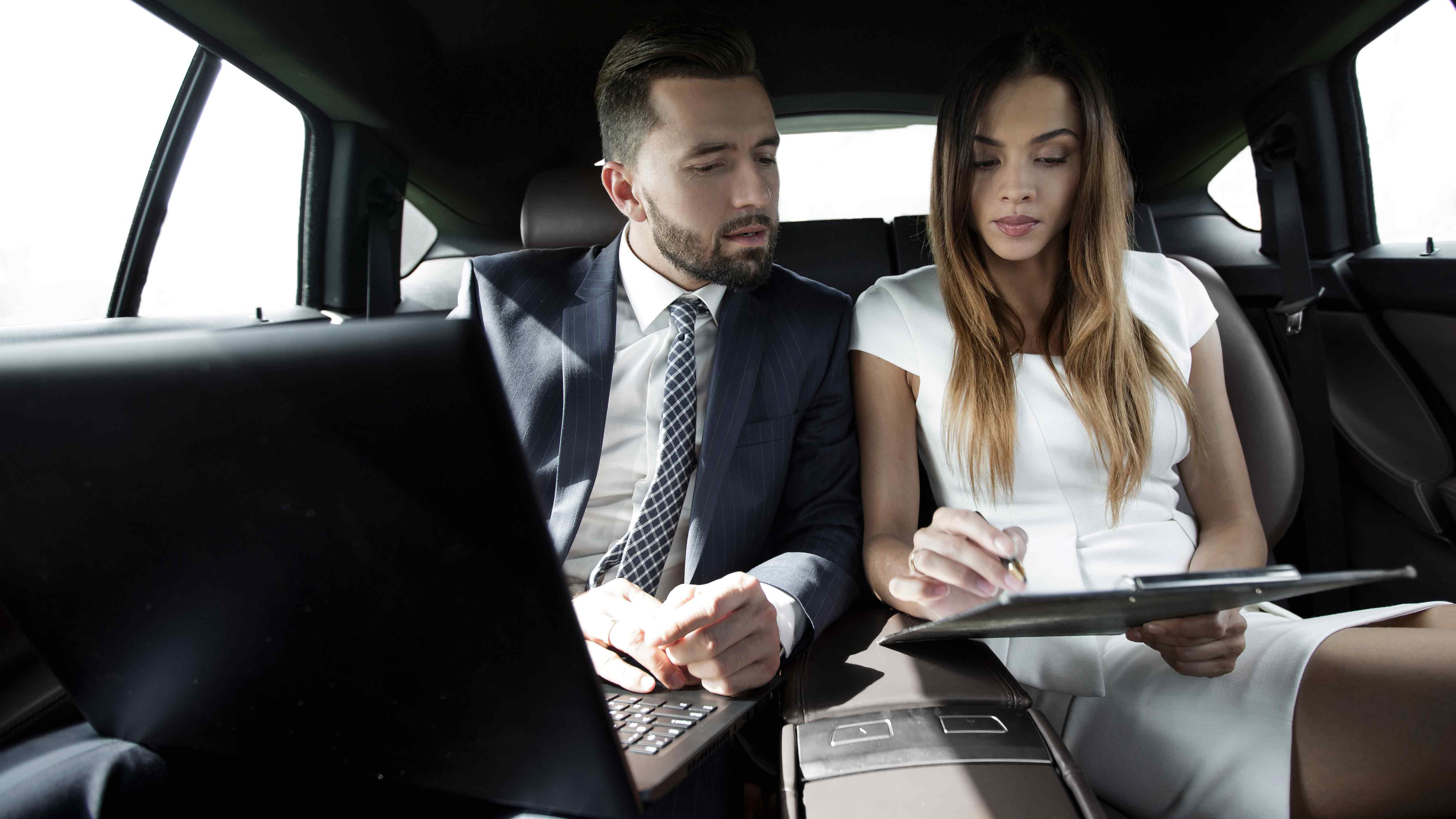 Professional man and woman corporate executives enjoying corporate chauffeur services